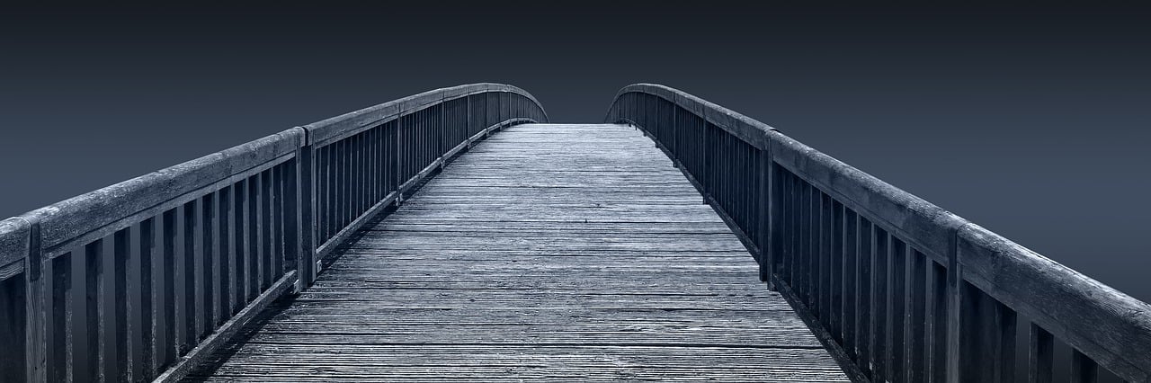 A wooden bridge over a calm stream, symbolizing bridging meditation and daily life.